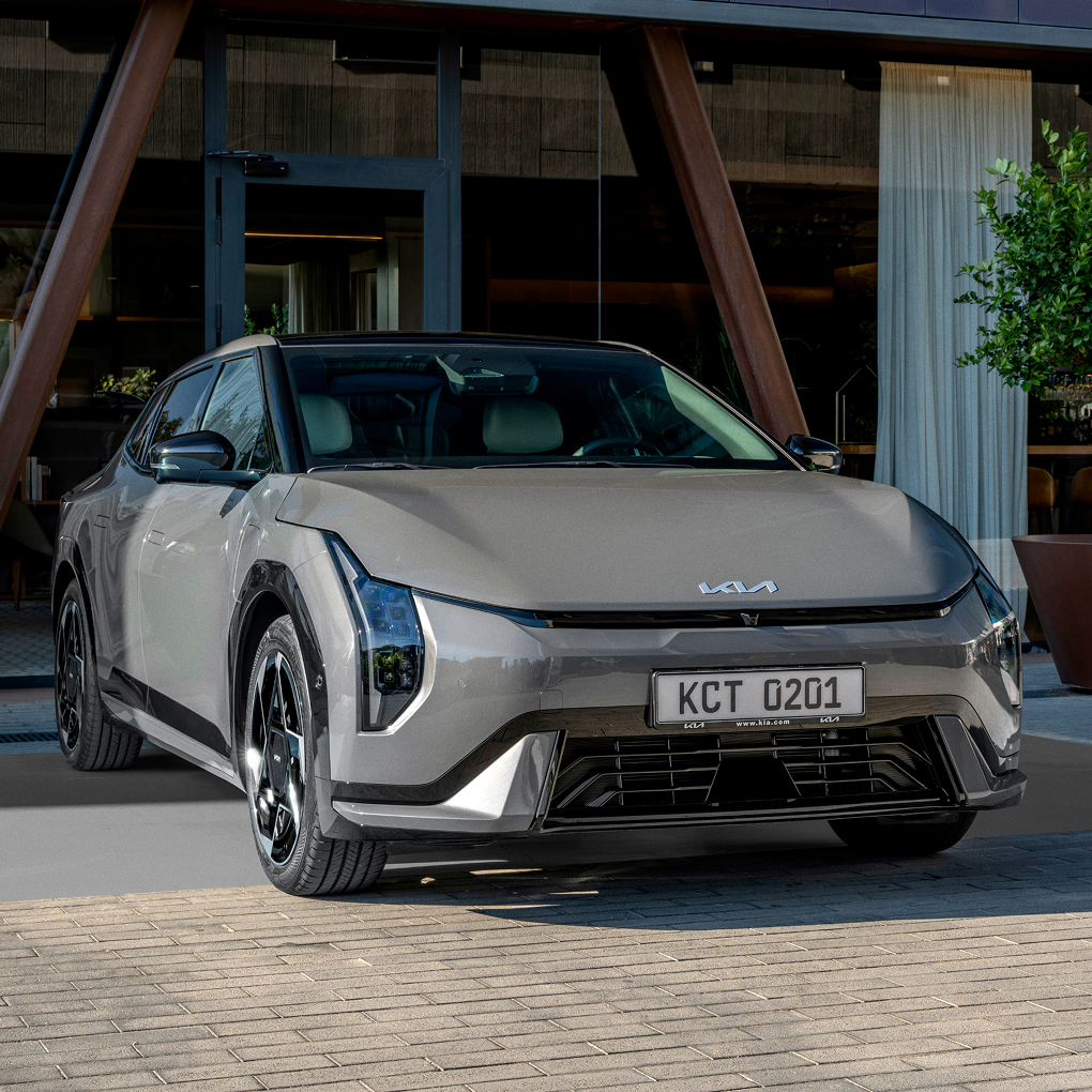 건물 앞에 주차된 기아 세단 차량 전면 이미지