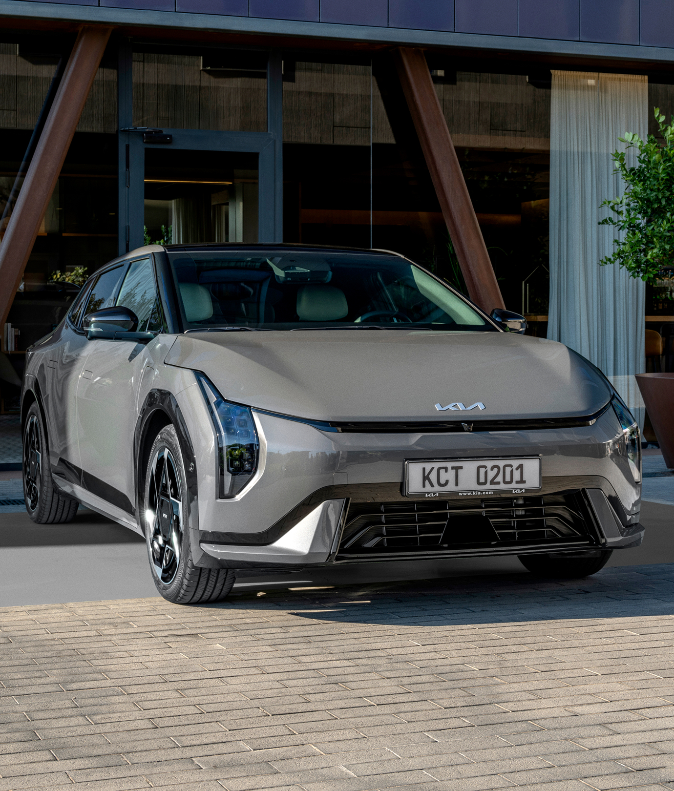 건물 앞에 주차된 기아 세단 차량 전면 이미지