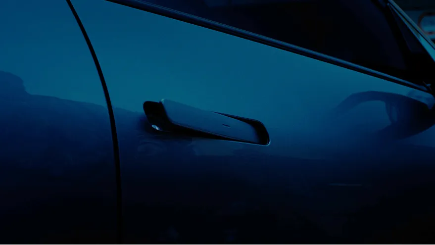 An approaching motorcycle visible in the side mirror as the Safe Exit Warning (SEW) alerts the occupants.