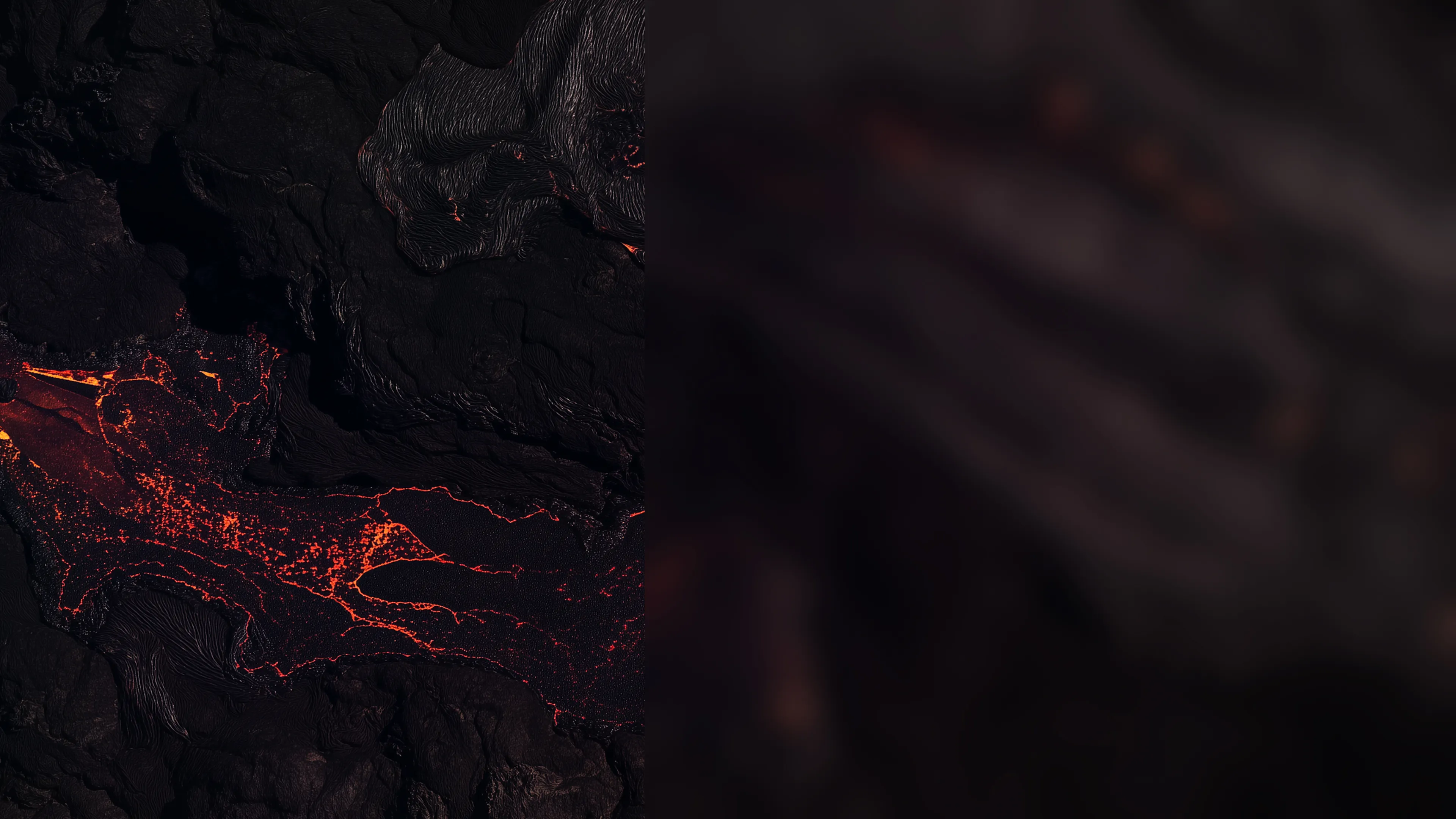 붉은 용암이 검은 화산 지형 위로 흐르는 모습 클로즈업 이미지