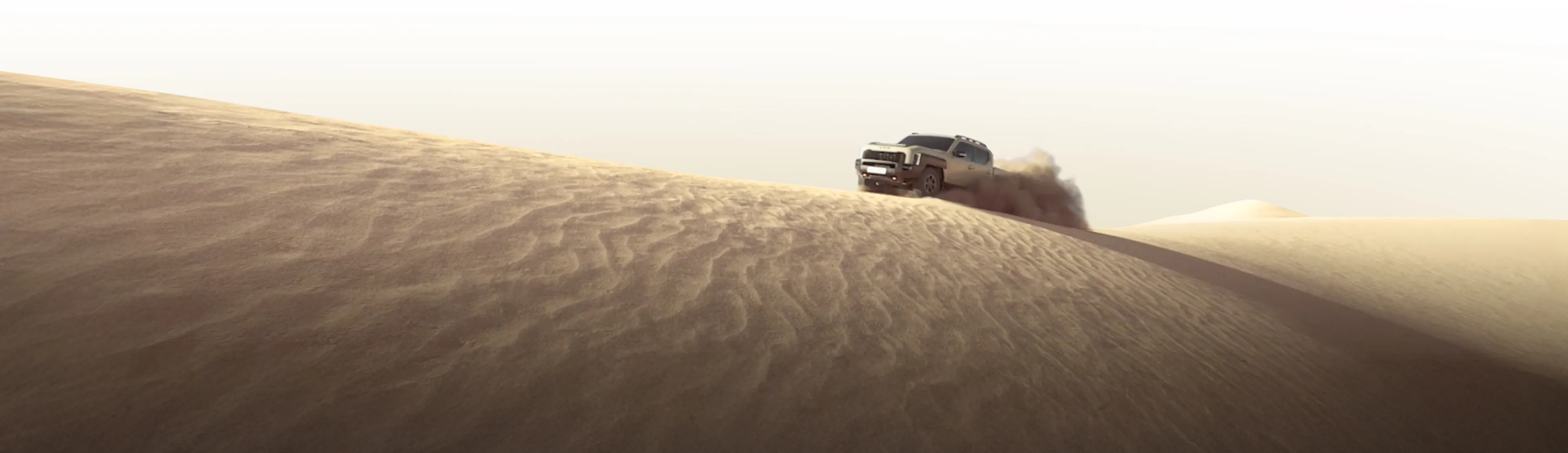 모래 언덕 너머로 멀리 보이는 기아 타스만 픽업트럭의 실루엣 모습