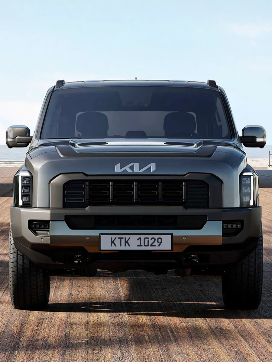 정면에서 바라본 사막 배경 위의 기아 타스만 픽업트럭 모습