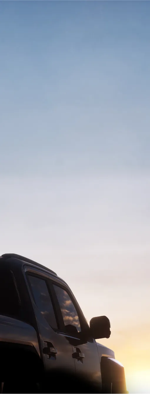 Rear silhouette view of the Kia Tasman pickup truck at dusk