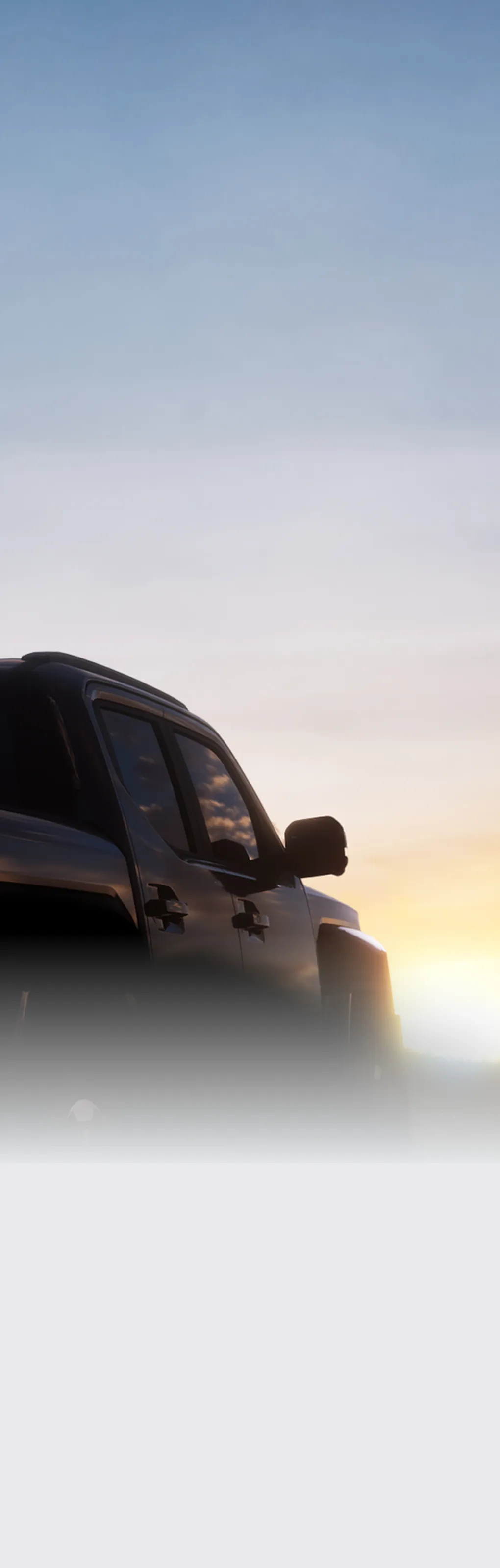 해 질 녘 실루엣으로 보이는 기아 타스만 픽업트럭의 후면 모습