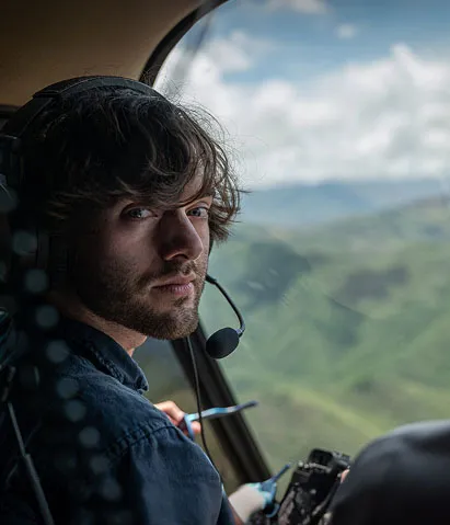 An operator monitoring ocean cleanup operations inside a helicopter