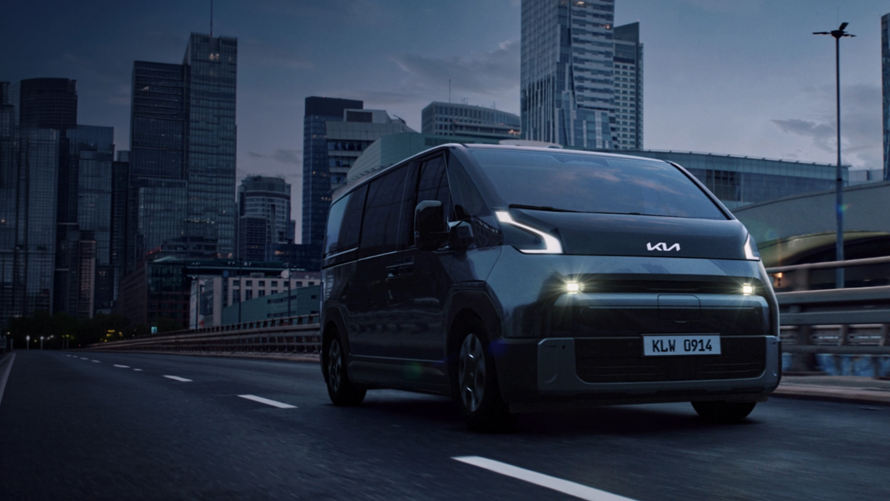 Front three-quarter view of the Kia PV7 driving on an urban road