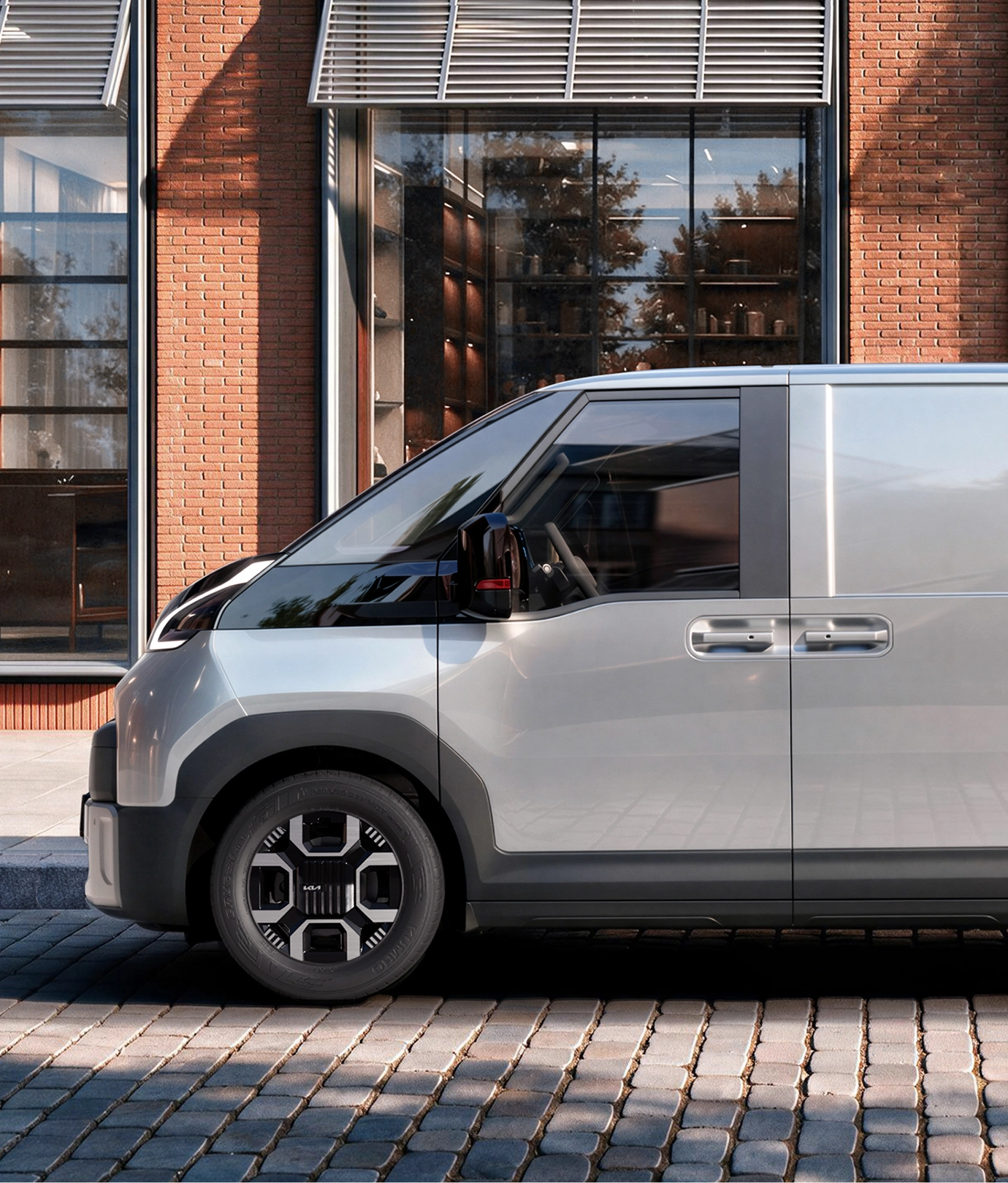 Side view of the Kia PV7 parked in front of a building