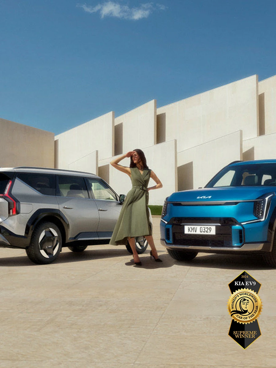 Image of two Kia EV9 vehicles parked in front of a modern building, winner of the 2024 Women’s Worldwide Car of the Year